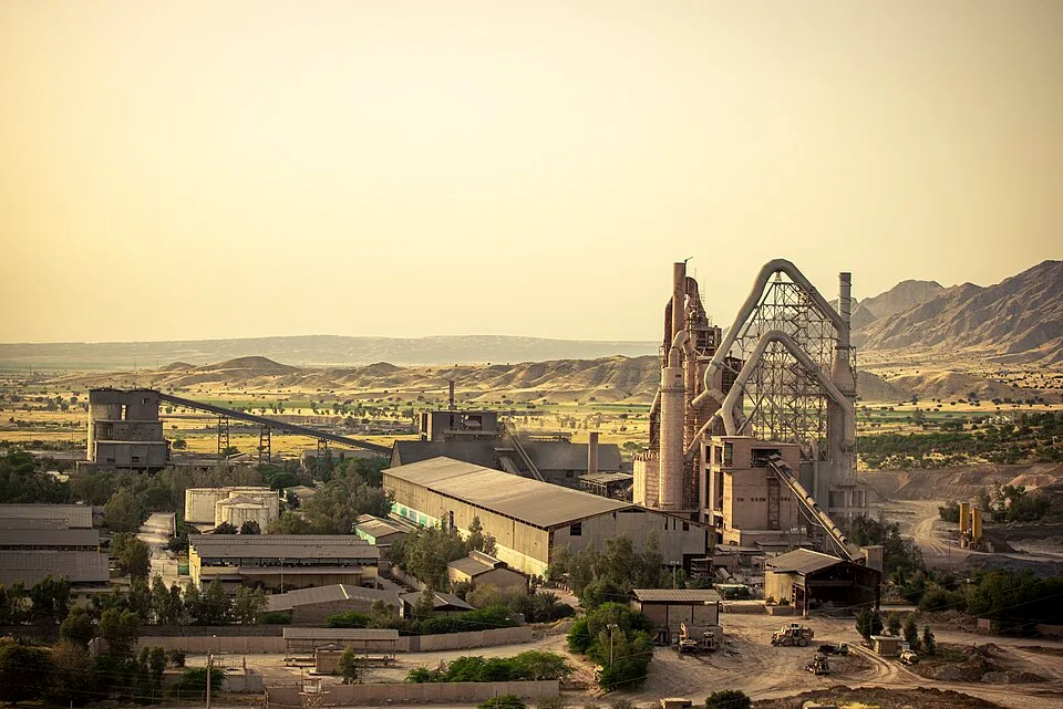 Fábrica de cimento em Behbahan, Irã, com torres de processo, transportadores, silos e galpões