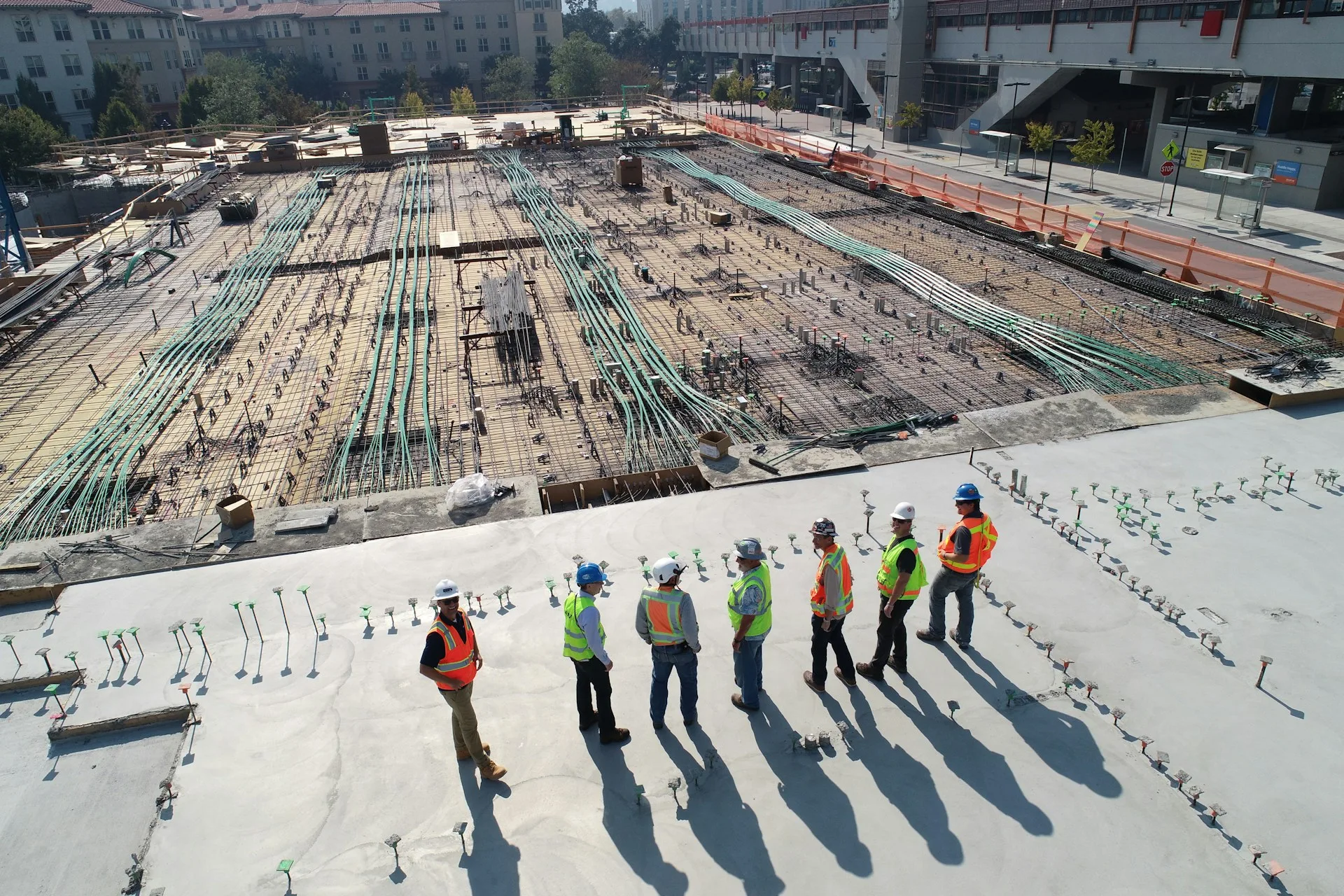 Equipe com capacetes e coletes de alta visibilidade reunida em um canteiro de obras