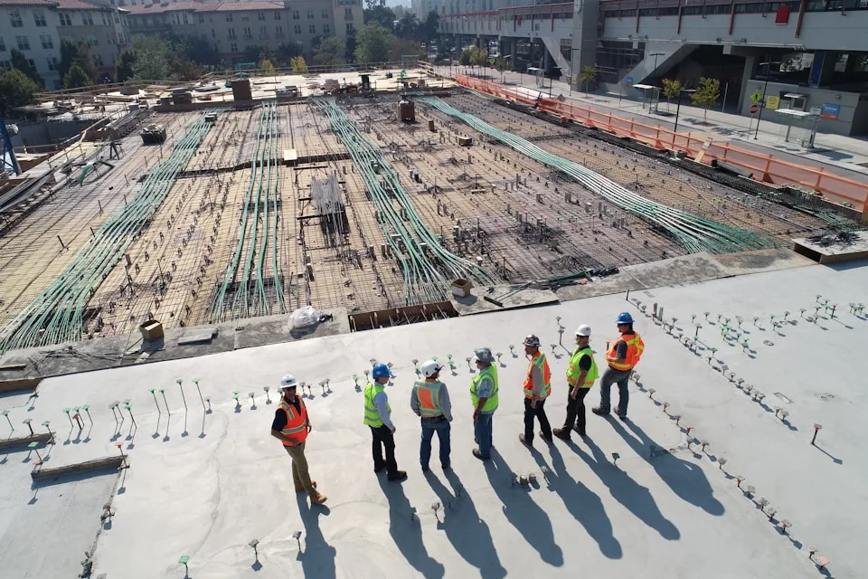Equipe com capacetes e coletes de alta visibilidade reunida em um canteiro de obras