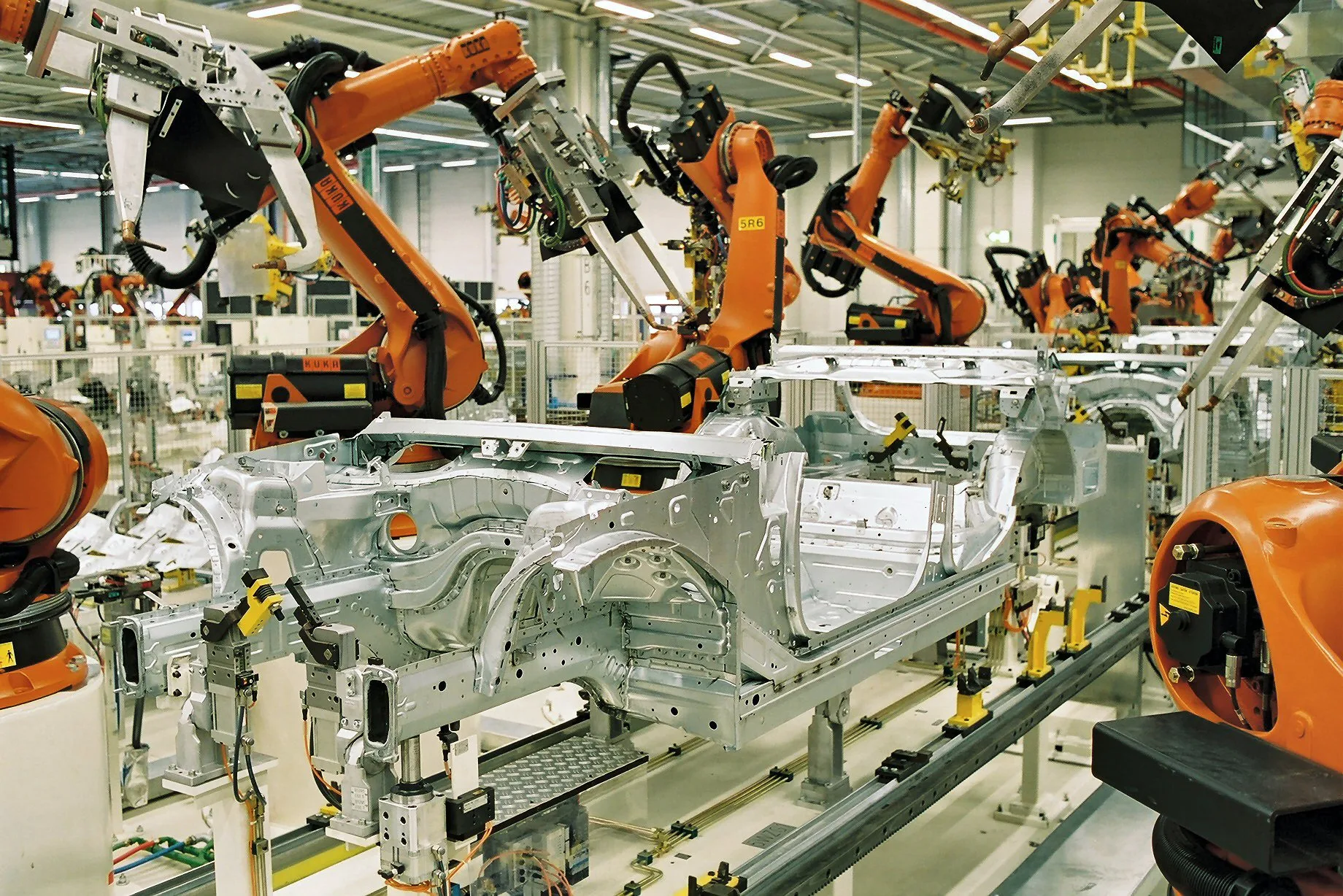 Robôs industriais trabalhando na montagem de carrocerias sem pintura