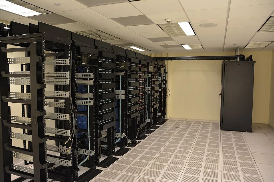 Fileiras de racks e equipamentos de rede em uma sala de data center